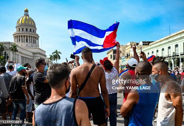 Cubans are seen outside Havana's Capitol during a demonstration against the government of Cuban President Miguel Diaz-Canel in Havana, on July 11,...