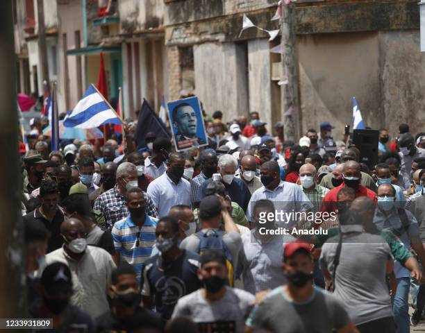 Cuban President Miguel Diaz-Canel walks alongside his supporters in the town of San Antonio de los Banos after the anti-government protests in which...
