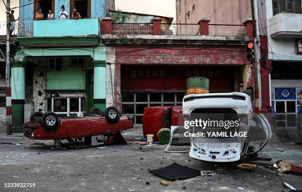 Police cars are seen overturned in the street in the framework of a demonstration against Cuban President Miguel Diaz-Canel in Havana, on July 11,...