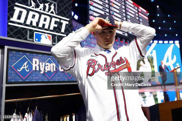 Pitcher Ryan Cusick puts on a jersey and cap after being selected 24th overall by the Atlanta Braves in the first round during the 2021 Major League...