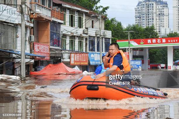 This photo taken on July 11, 2021 shows rescuers searching for residents affected by flood following heavy rains in Dazhou, in China's southwestern...