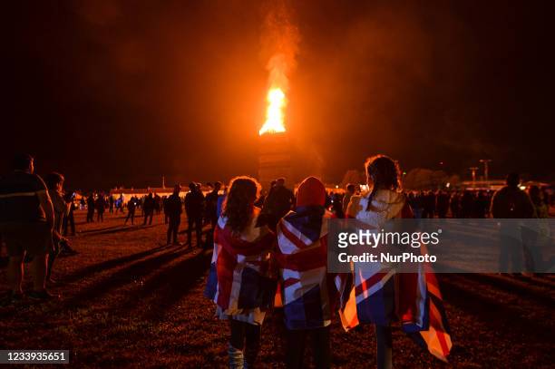 People watch a large bonfire during the Eleventh Night marking the start of the unionist Twelfth celebrations, in Craigy Hill, Larne. Tonight, large...