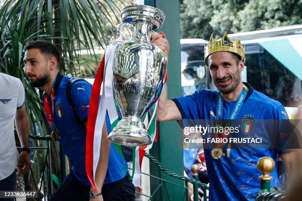 This photo obtained from Italian news agency Ansa shows Italy's captain Giorgio Chiellini carrying the trophy next to goalkeeper Gianluigi Donnarumma...