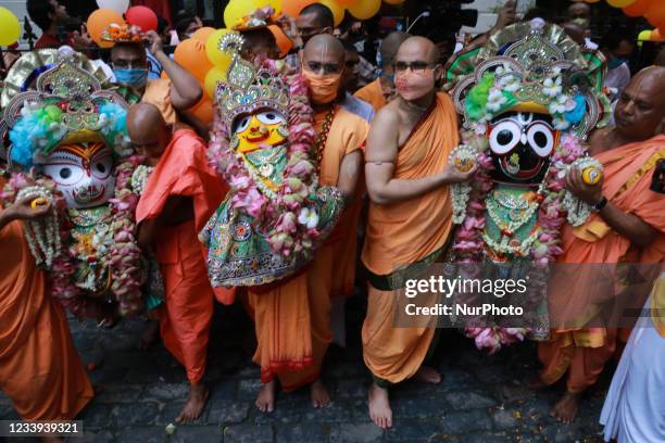 Temple priests and Hindu devotees carry an idol of Lord Jagannath as a symbolic gesture after the Rath Yatra procession was cancelled amid concerns...