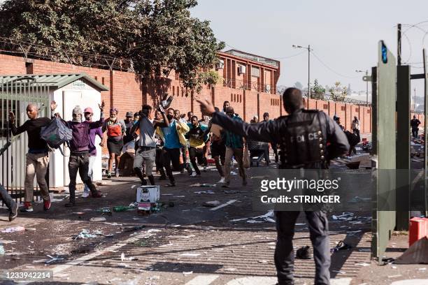 People flee from the Springfiled Park Mall in Durban on July 12, 2021. - South Africa's army said Monday it was deploying troops to two provinces,...
