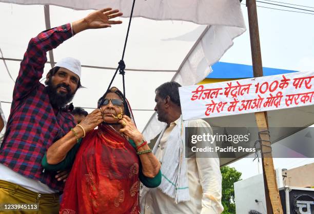 Congress party activist stands with a noose around her neck during protest against Central's Modi Government over continuous hike in prices of...