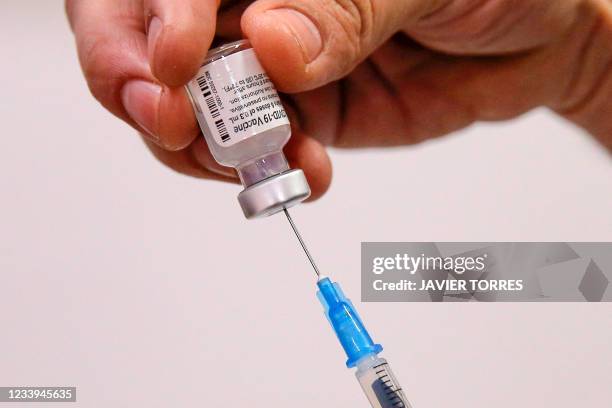Health workers fills a syringe with a dose of the Pfizer-BioNTech vaccine against COVID-19 at a vaccination centre in Santiago, on July 12, 2021.