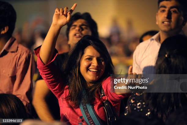 Pakistani woman dances to a song during the performance of the Pakistani rock band Jal during the Pakistani Independence Day celebrations in Markham,...
