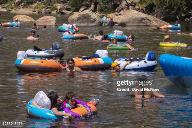 People cool off in the Kern River, which is running at about one quarter capacity toward Lake Isabella, as a heatwave brings a temperature of 106...