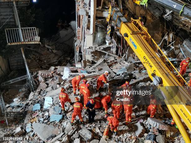 This photo taken on July 12, 2021 shows rescuers searching at the site of a hotel after it collapsed leaving at least one dead and 10 others missing...