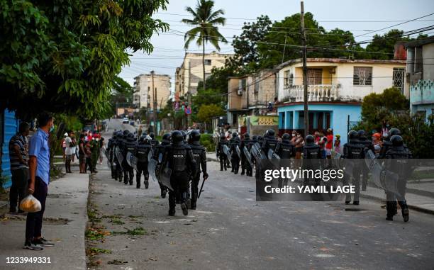 Riot police walk the streets after a demonstration against the government of President Miguel Diaz-Canel in Arroyo Naranjo Municipality, Havana on...