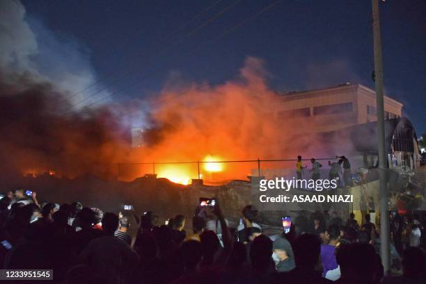 People take images of flames as a massive fire engulfs the coronavirus isolation ward of Al-Hussein hospital in the southern Iraqi city of Nasiriyah,...