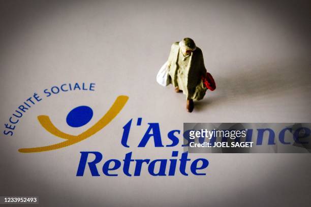 Un personnage miniature est photographié le 07 juin 2012 à Paris, sur un document de l'assurance maladie portant le logo de la Sécurité sociale....