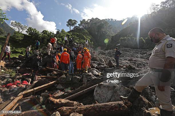 Members of National Disaster Response Force inspect the site of a landslide after heavy rains at Boh village in Kangra district of India's Himachal...