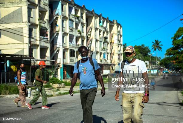 People walk along a street of La Ginera in Arroyo Naranjo Municipality in Havana, on July 13, 2021. - Cuban authorities have cut access to major...