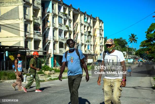 People walk along a street of La Ginera in Arroyo Naranjo Municipality in Havana, on July 13, 2021. - Cuban authorities have cut access to major...