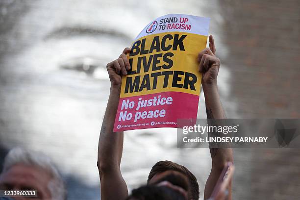 Anti-racism protestors demonstrate by a mural of England forward Marcus Rashford after it was defaced on July 13, 2021 in Manchester, northwest...