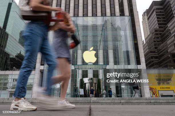 People walk past an Apple retail store on July 13, 2021 in New York City. Stock markets were slightly softer on news of the biggest jump in US...