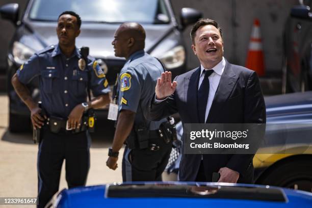 Elon Musk, chief executive officer of Tesla Inc., right, waves while departing court during the SolarCity trial in Wilmington, Delaware, U.S., on...