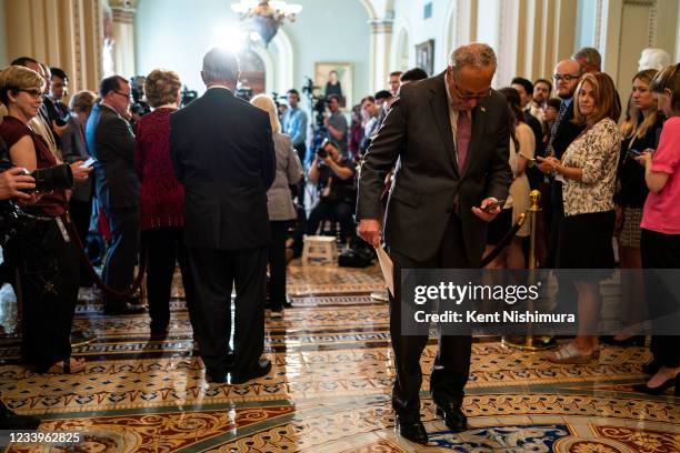 Senate Majority Leader Chuck Schumer checks his cell phone in the Ohio Clock Corridor during a press conference in the U.S. Capitol Building on...