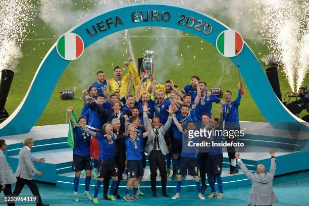 Giorgio Chiellini of Italy holds the trophy while the italian team celebrate the victory during the prize ceremony at the end of the Uefa Euro 2020...