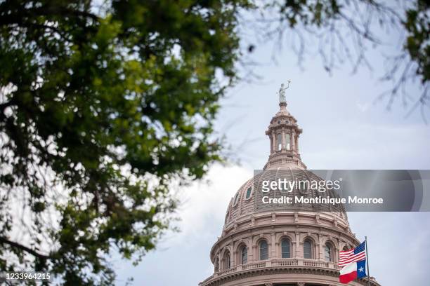 The U.S. And Texas flags wave outside the Texas Capitol on July 13, 2021 in Austin, Texas. The Texas House voted to arrest Democrats who fled the...