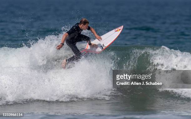 Huntington Beach, CA USA Surfing Team member Kolohe Andino of San Clemente, floats over a breaking section of a small wave as Brett Simpson, of...