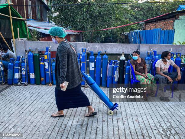 People wait to refill their empty oxygen tanks outside a mosque amid a surge in COVID-19 cases in Yangon, Myanmar on July 14, 2021. Due to the rising...