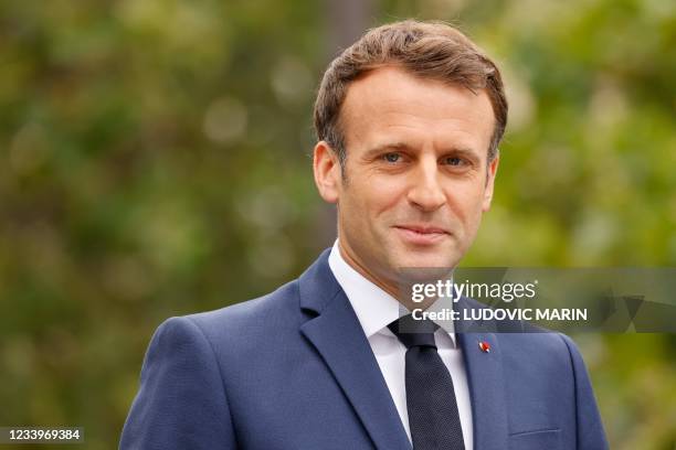 French President Emmanuel Macron stands in the command car as he reviews troops prior to the annual Bastille Day military parade on the...