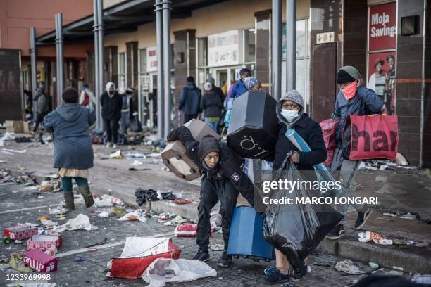 Looters take away few items left to grab in a vandalised mall in Vosloorus, on July 14, 2021. The raging unrest first erupted last Friday after...