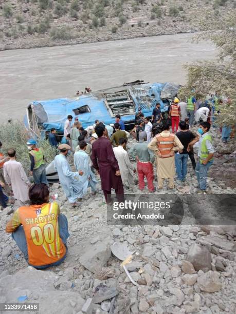 Pakistani people are seen in the site where was bus fell into a ravine following a bomb attack, in Kohistan district in Northern Pakistani region, on...
