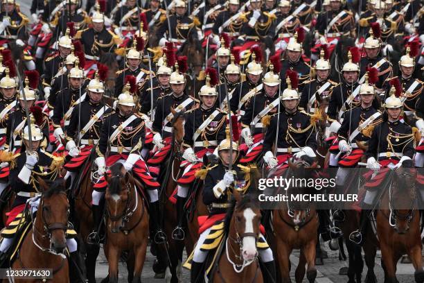 Republican Guard cavalry officers rides their horses on the Champs-Elysees avenue during the annual Bastille Day military parade in Paris on July 14,...