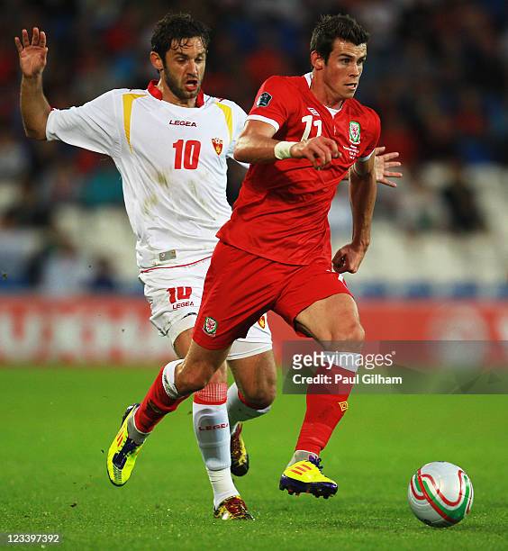 Gareth Bale of Wales holds off the challenge of Radomir Dalovic of Montenegro during the UEFA EURO 2012 group G qualifying match between Wales and...