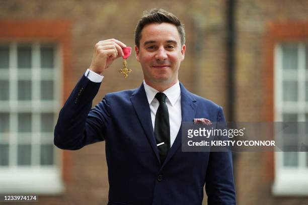 British playwright James Graham poses with his medal after being appointed an Officer of the Order of the British Empire for services to Drama and...