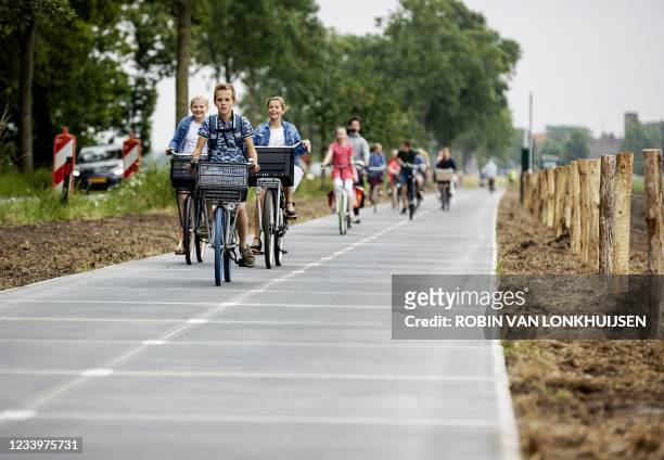 Primary school students cycle on the longest solar cycle path in the world in Maartensdijk in the Dutch province of Utrecht on the day of its opening...