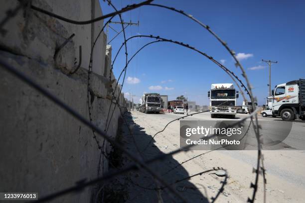 Trucks loaded with goods enter the Gaza Strip from Israel through the Kerem Shalom crossing in Rafah in the southern Gaza Strip on July 14, 2021. The...