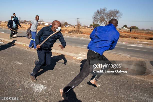 Community member beats a person suspected of looting on July 14, 2021 in Vosloorus, Johannesburg, South Africa. South Africa has deployed the...