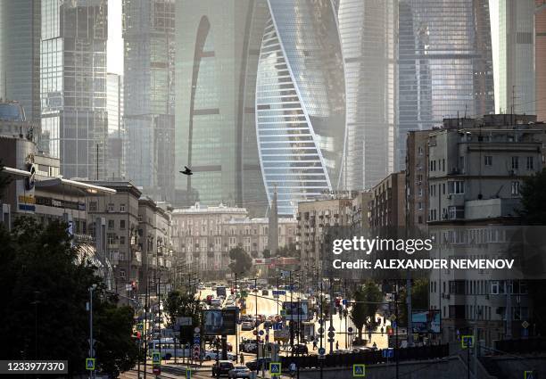 View shows cars moving along a sunny street in western Moscow in front of Moscow's International Business Centre skyline Moscow on July 14, 2021...