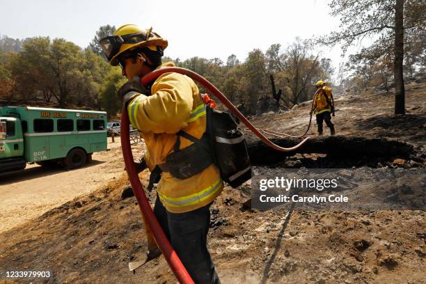 Oakhurst, California Brandon Medina, left, and Colby Humphries, right, both of the Yolo County Strike Team, put out smoldering patches, remnants of...