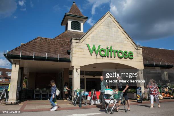 Shoppers leave a branch of Waitrose on 14th July 2021 in Wokingham, United Kingdom. John Lewis and Waitrose have announced plans to cut 1,000 jobs as...