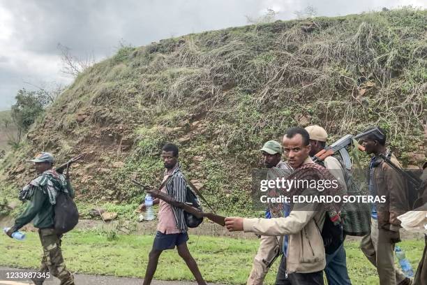 Members of the Amhara militia walk along the road in a rural area near the village of Adi Arkay, 180 kilometers northeast from the city of Gondar,...