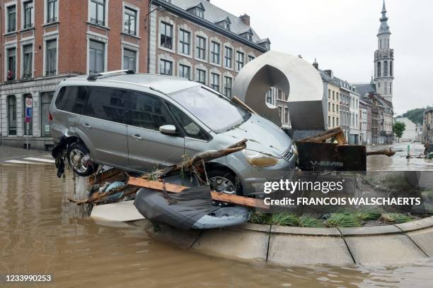 Picture taken on July 15, 2021 shows a car in suspension at a roundabout in the Belgian city of Verviers, after heavy rains and floods lashed western...