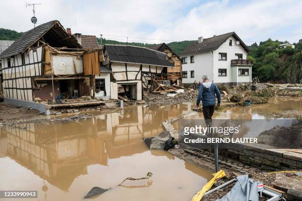 Man walks through the floods towards destroyed houses in Schuld near Bad Neuenahr, western Germany, on July 15, 2021. Heavy rains and floods lashing...