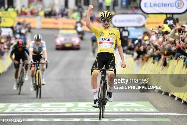 Team UAE Emirates' Tadej Pogacar of Slovenia wearing the overall leader's yellow jersey celebrates as he crosses the finish line during the 18th...
