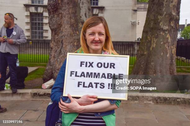 Demonstrator holds a placard saying 'Fix Our Flammable Flats' during the building safety crisis protest. Tenants and leaseholders gathered outside...