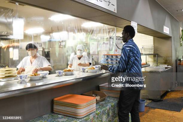 South Sudan's Paralympic athlete Kutjang Michael Machiek Ting picks up lunch at a cafeteria in the basement of Maebashi city hall in Maebashi, Gunma...