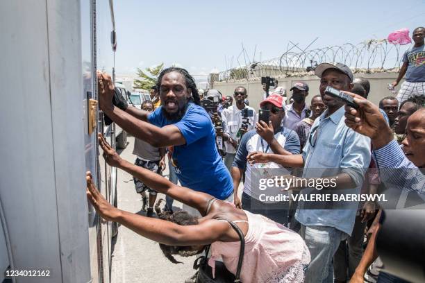Supporters cheer and surround an ambulance carrying former Haitian President Jean-Bertrand Aristide after he arrived at the airport in Port-au-Prince...