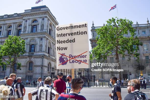 Protester holds a placard saying 'Government Intervention Needed Now' during the demonstration outside Downing Street. Newcastle United Football Club...