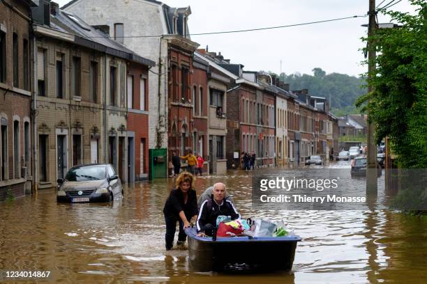 People use a boat to bring man out of home following a severe storm on July 16, 2021 in 'Rue de Tilff' in Angleur, a district from Liège, Belgium. A...