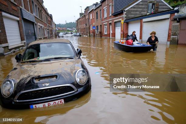 People use a boat to bring water and food to neigbours following a severe storm on July 16, 2021 in 'Rue de Tilff' in Angleur, a district from Liège,...